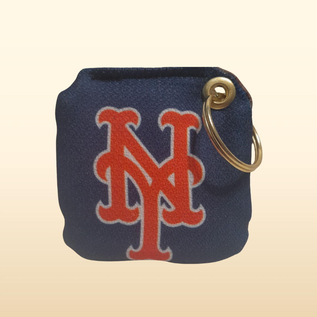 Navy blue keychain pouch with red NY Mets logo and gold ring on beige background