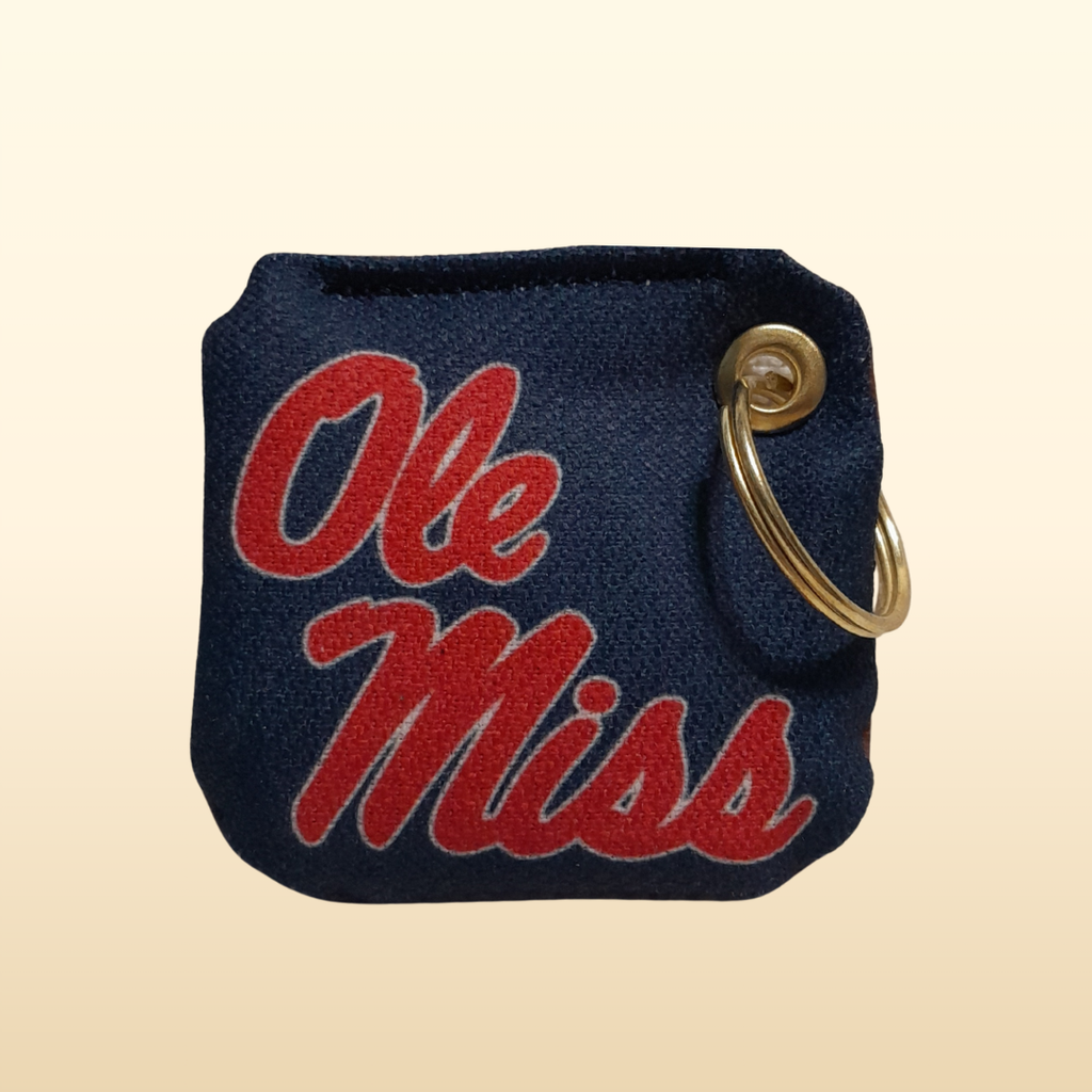 Navy keychain pouch with 'Ole Miss' text on a beige background
