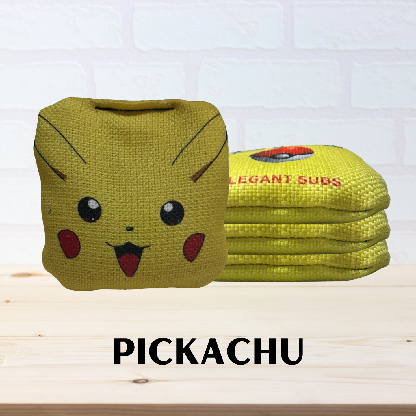 Mini cornhole bags with Pikachu design on a white brick wall background