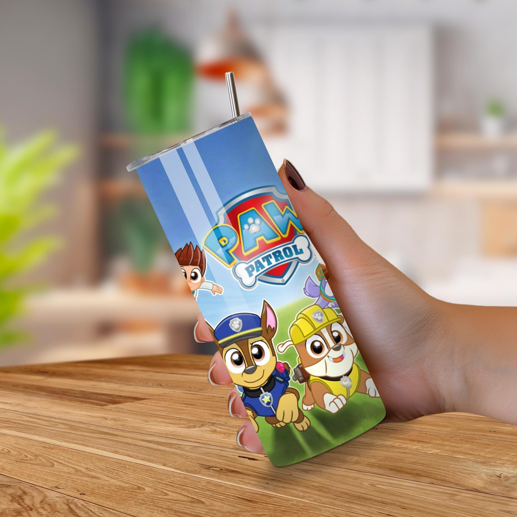 20oz Tumbler with Paw Patrol design held by a hand on a wooden surface