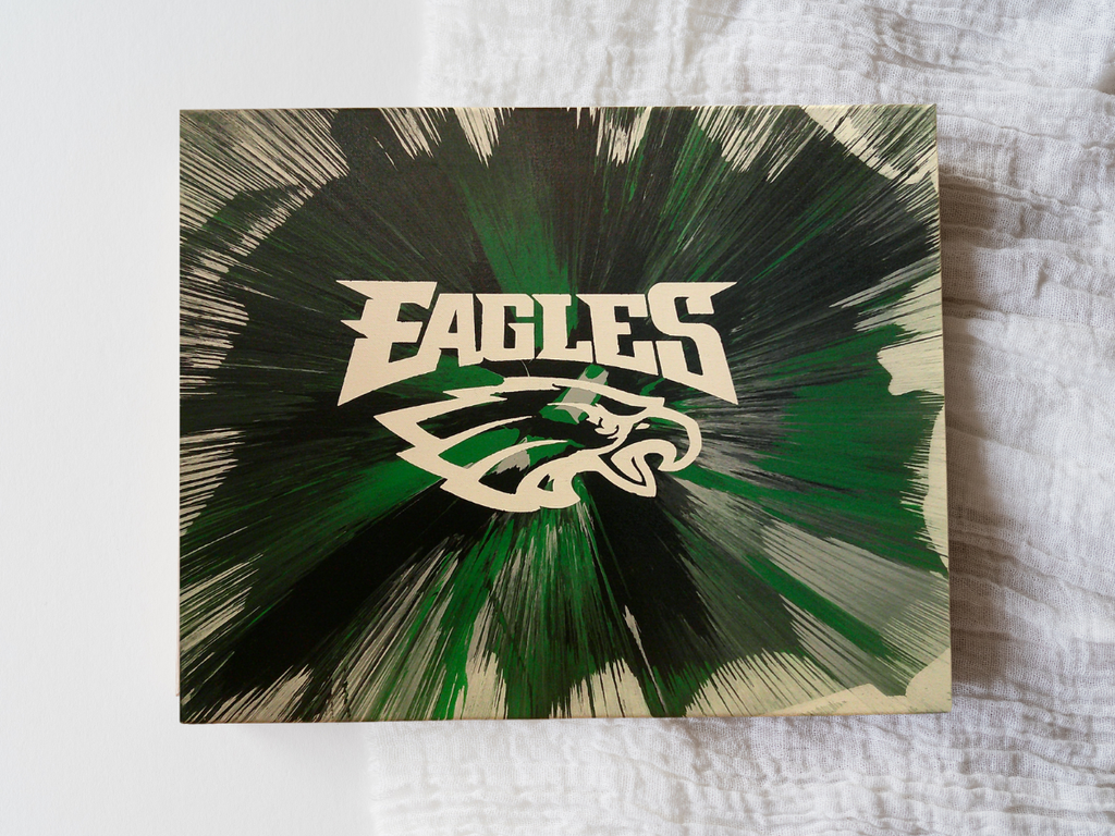 Spin Art canvas of Eagles logo with dynamic green and black design on a textured surface