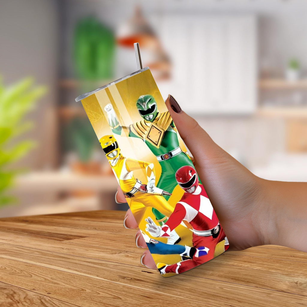 Tumbler with Power Rangers design held by a hand on a wooden surface.