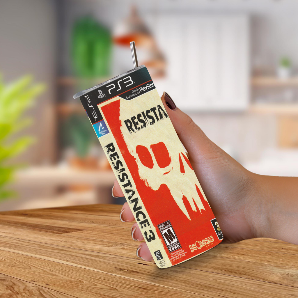 A hand holding a PS3-themed 20oz stainless steel tumbler mockup with a straw, featuring the 'Resistance 3' graphic and PlayStation branding, set against a blurred indoor background.