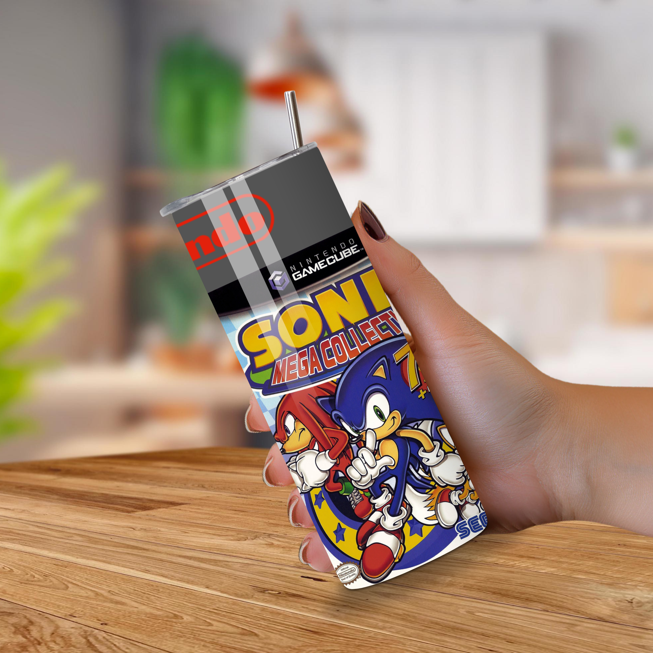 20 oz tumbler with Sonic the Hedgehog design held by a hand on a wooden surface.