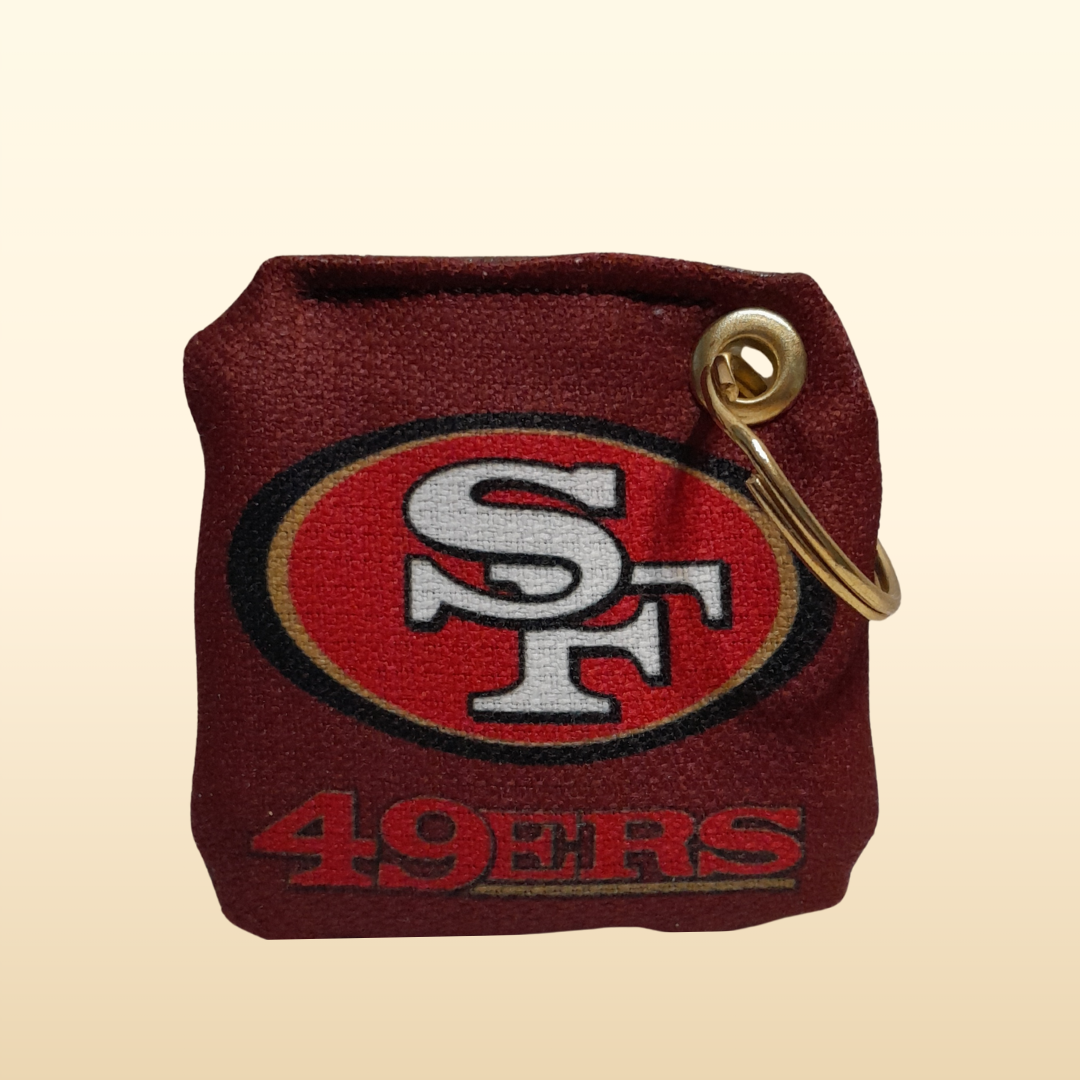 Keychain with San Francisco 49ers logo on a beige background