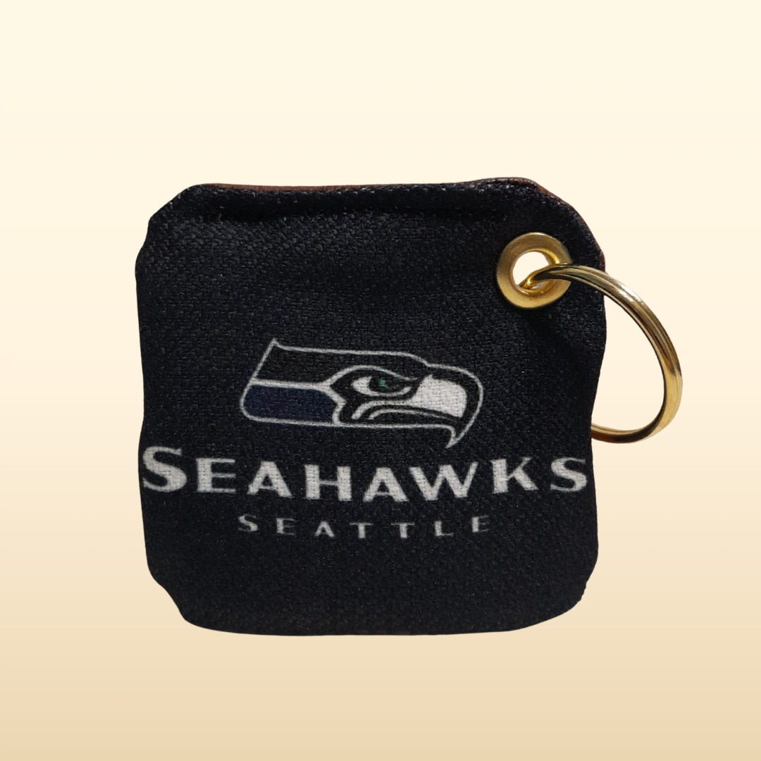 Black keychain with Seattle Seahawks logo on a beige background