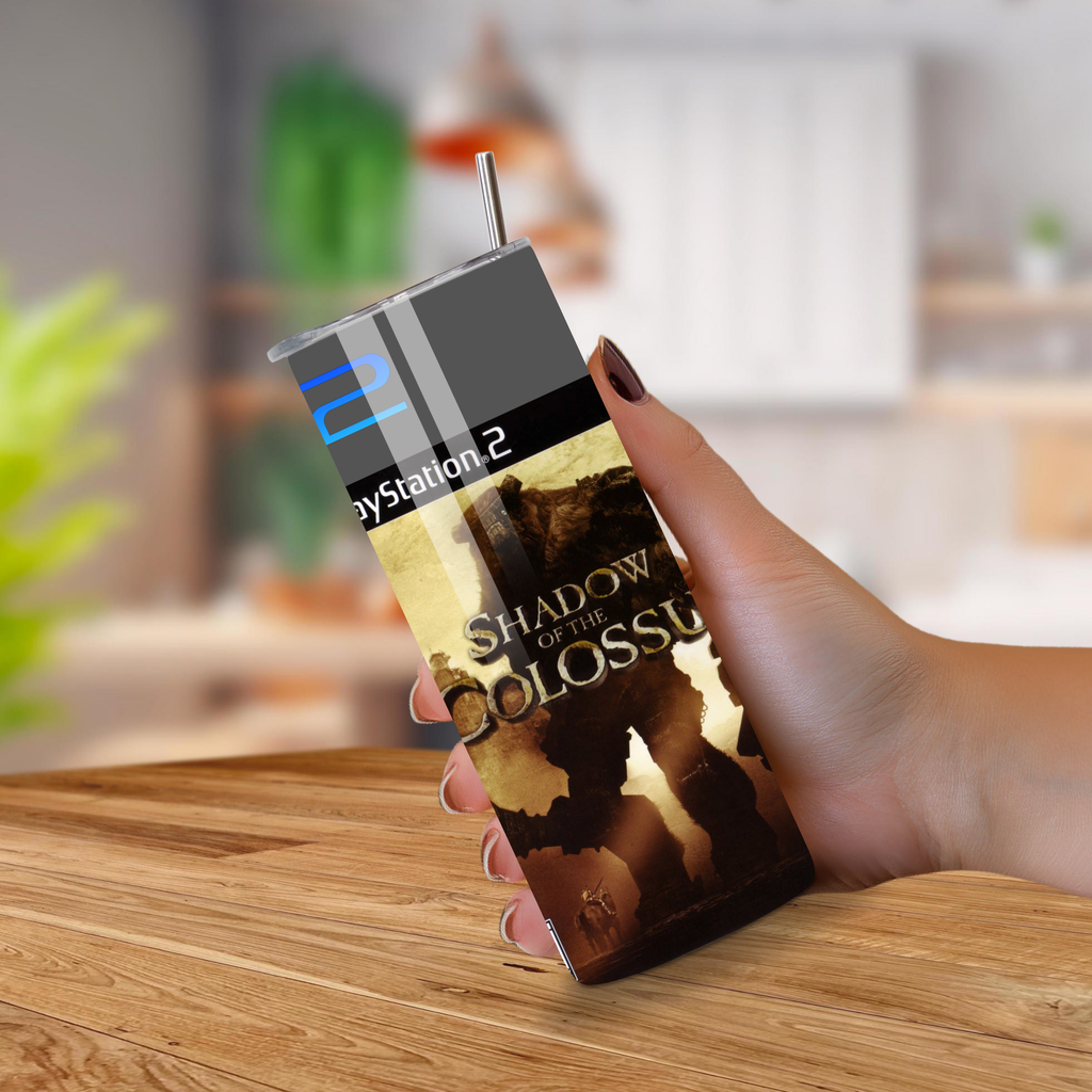 Hand holding a 20oz tumbler with PS2 Shadow of the Colossus banding with a wood background. 