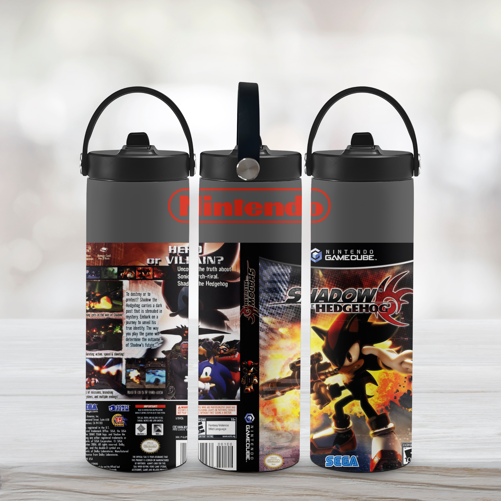 Three sports water bottles with Shadow the Hedgehog video game-themed designs on a light wooden surface.