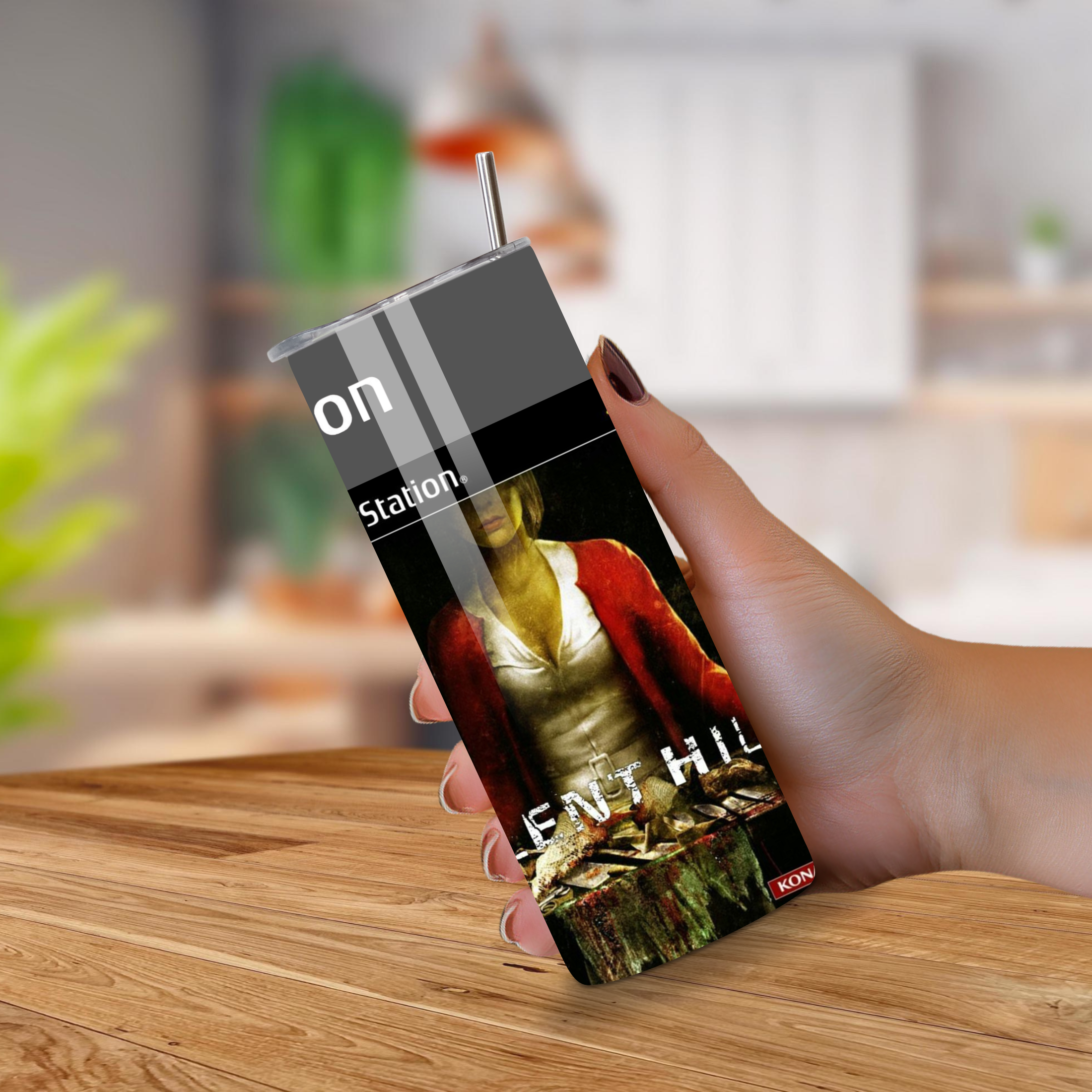 Person holding a 20oz tumbler with a Silent Hill design on a wooden surface