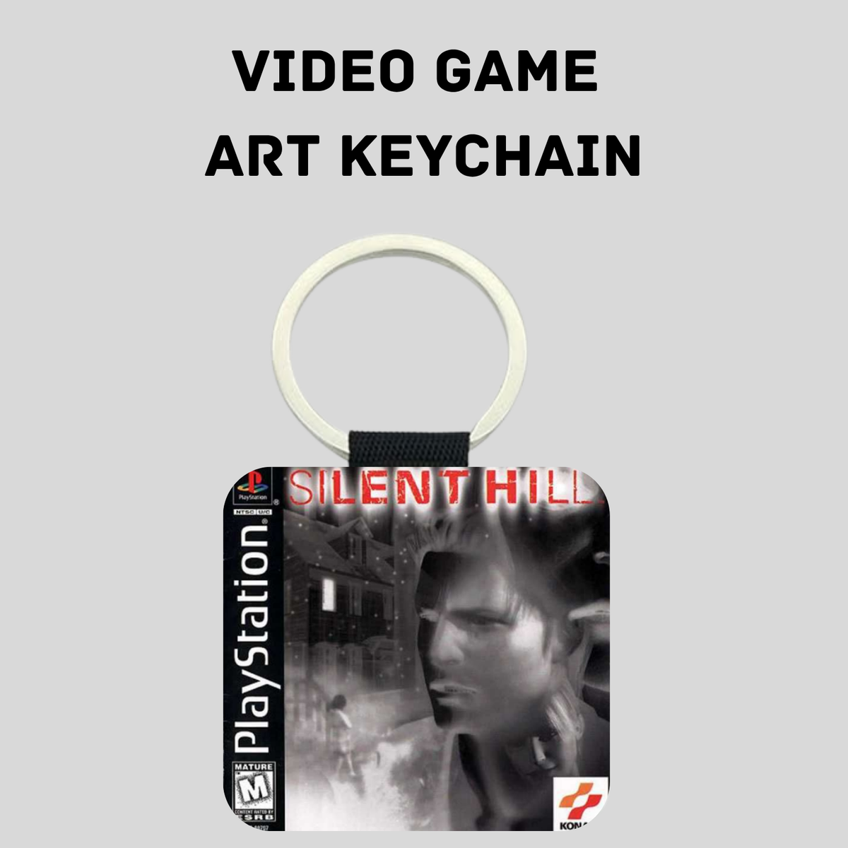 A PlayStation Silent Hill video game art keychain on a light gray background with the text 'VIDEO GAME ART KEYCHAIN' above it. The keychain features a square pendant with artwork from the Silent Hill game, including the PlayStation logo and the KONAMI logo.