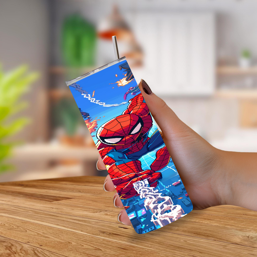 A hand holding a 20oz tumbler with a stainless-steel straw, featuring a vibrant Spider-Man graphic print, set against a blurred kitchen background.