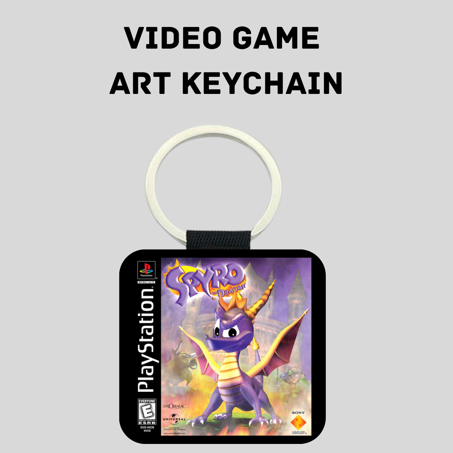 A PlayStation video game art keychain featuring Spyro the Dragon, shown against a light gray background with the text 'VIDEO GAME ART KEYCHAIN' above it. The keychain has a white plastic ring, a black strap, and a square black face with Spyro artwork and PlayStation branding.