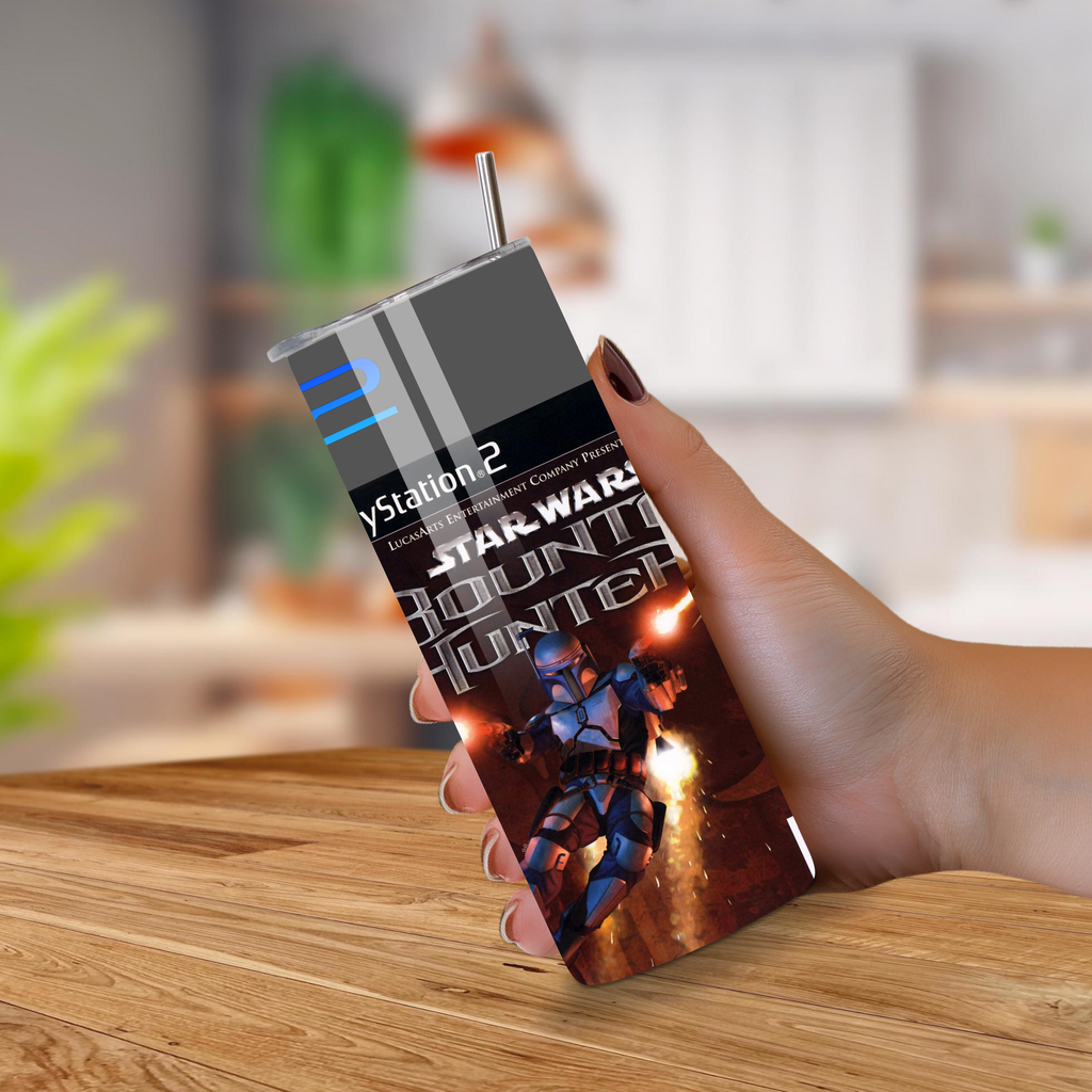 Hand holding a PlayStation 2 20oz tumbler with Star Wars: Bounty Hunter packaging on a wooden surface.