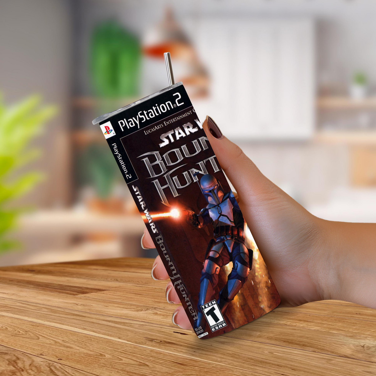 A hand holding a 20oz tumbler featuring Star Wars: The Bounty Hunter artwork, with a straw inserted at the top, set against a blurred indoor background.