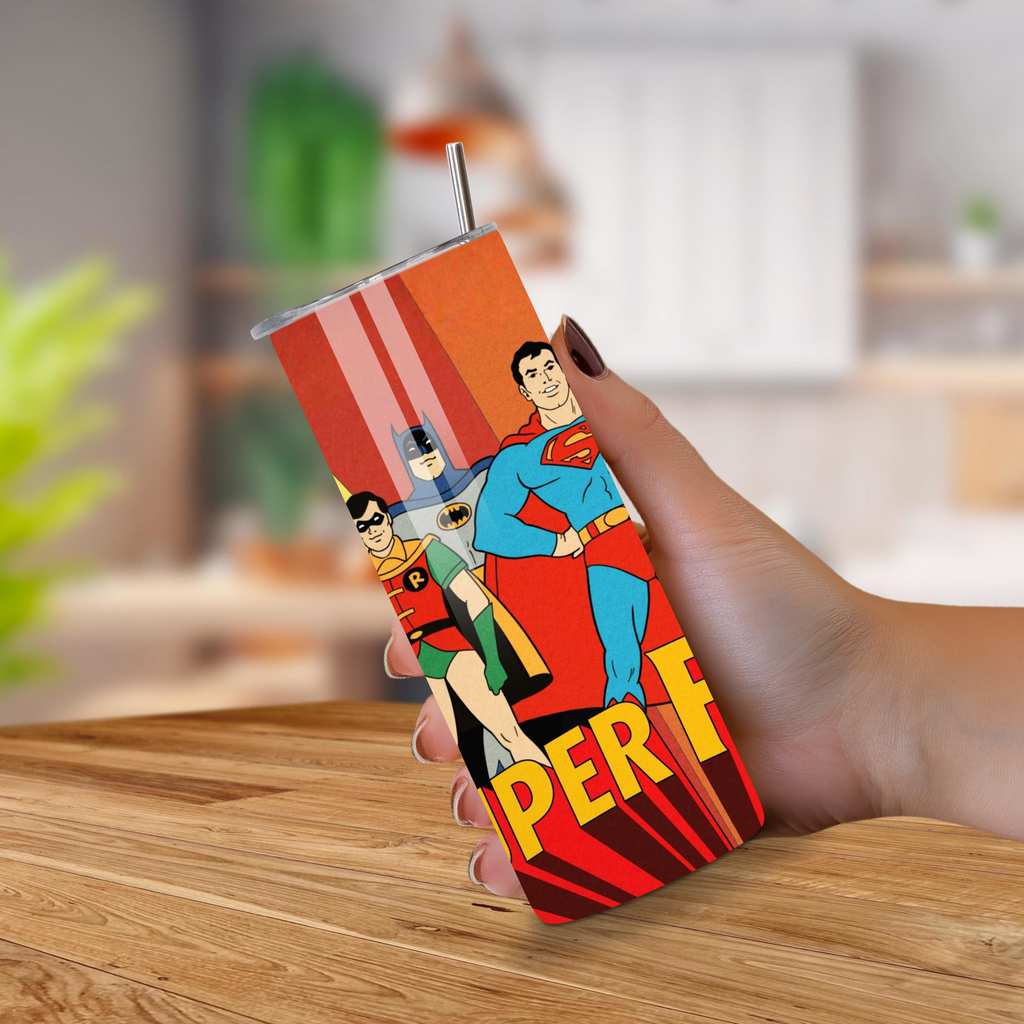 Tumbler with Super Friends design held by a hand on a wooden surface