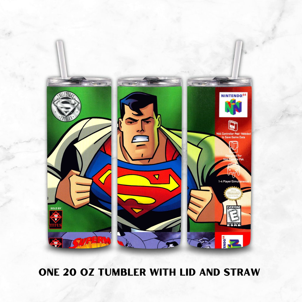 Three views of a 20 oz tumbler with lid and straw, featuring retro video game-style artwork of Superman on a green background. The left view shows the Superman logo and a circular emblem, the center shows Superman's face and chest emblem, and the right view shows Nintendo 64 branding and game rating seals.