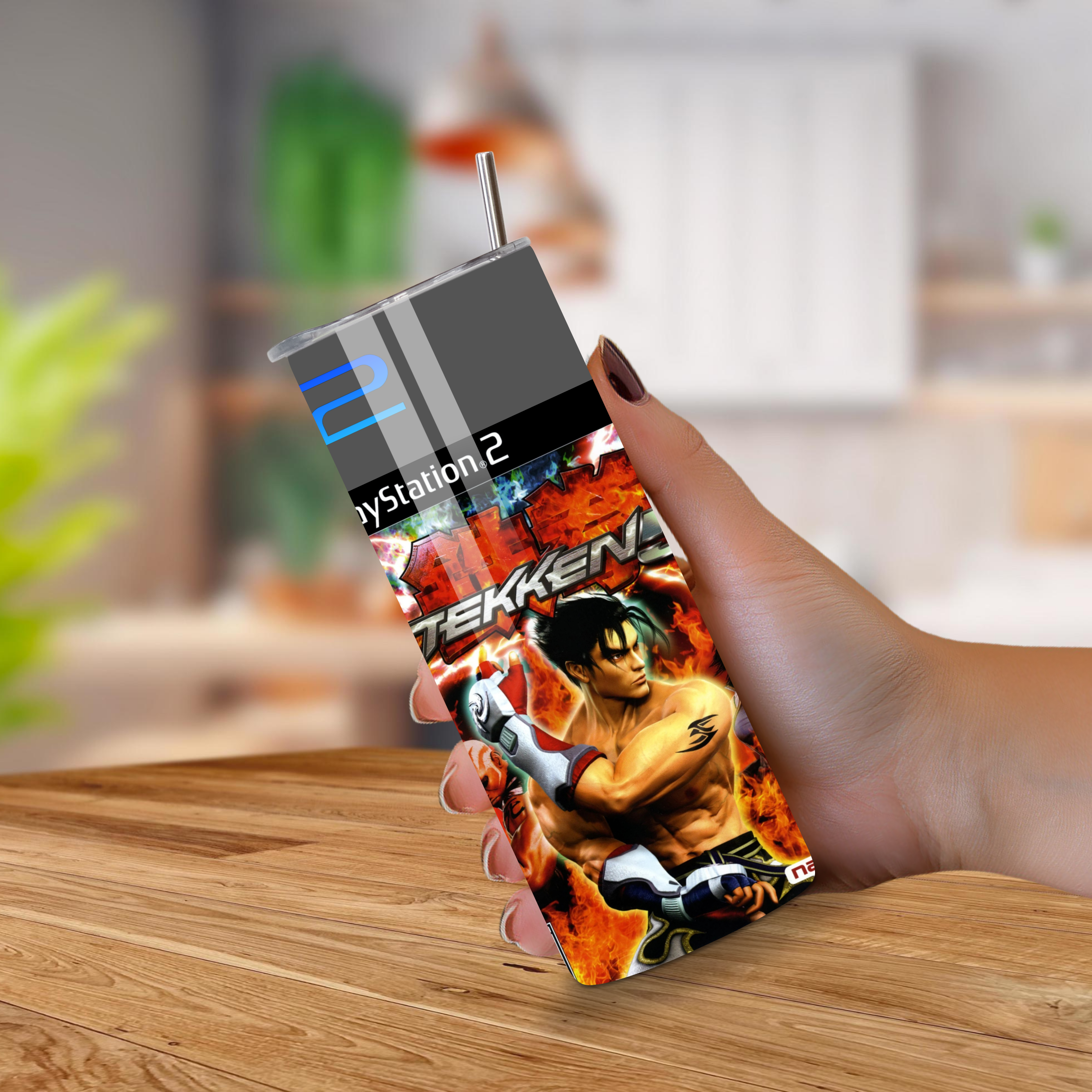 Tumbler with Tekken 5 design held by a hand on a wooden surface