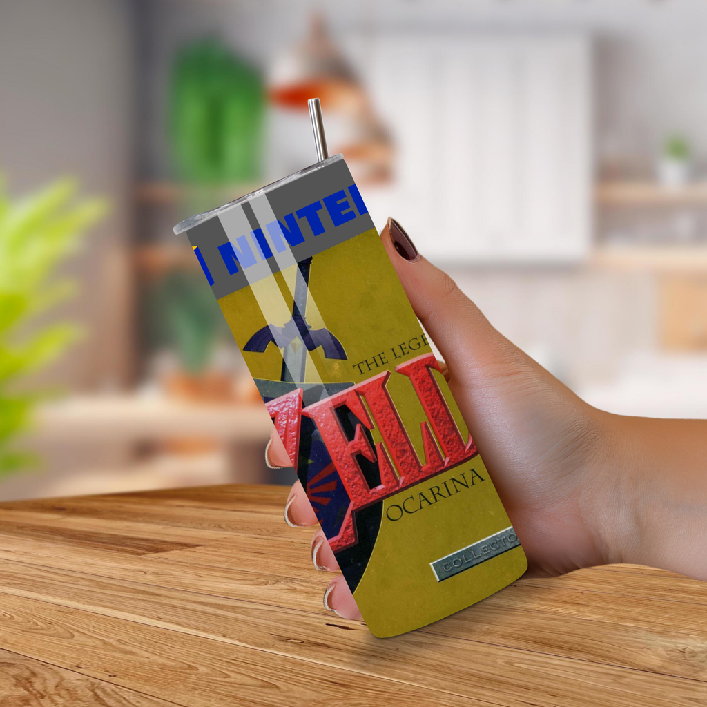 Hand holding a colorful 'The Legend of Zelda' Ocarina tumbler on a wooden surface.