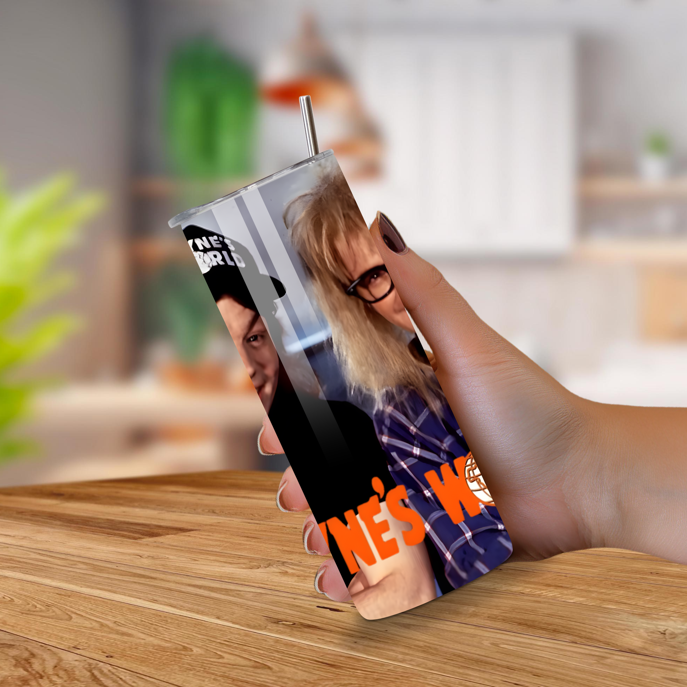 Person holding a tumbler with a design of two people from Wayne's World and text on a wooden table.