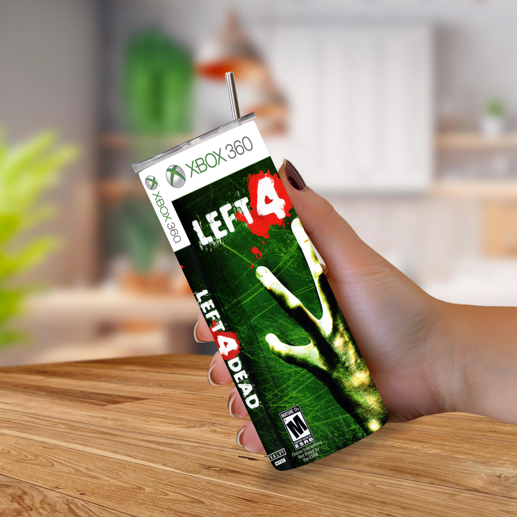 A hand holding a 20oz tumbler styled with the Left 4 Dead 4 game cover art, featuring a straw and Xbox 360 branding, set against a blurred kitchen background.